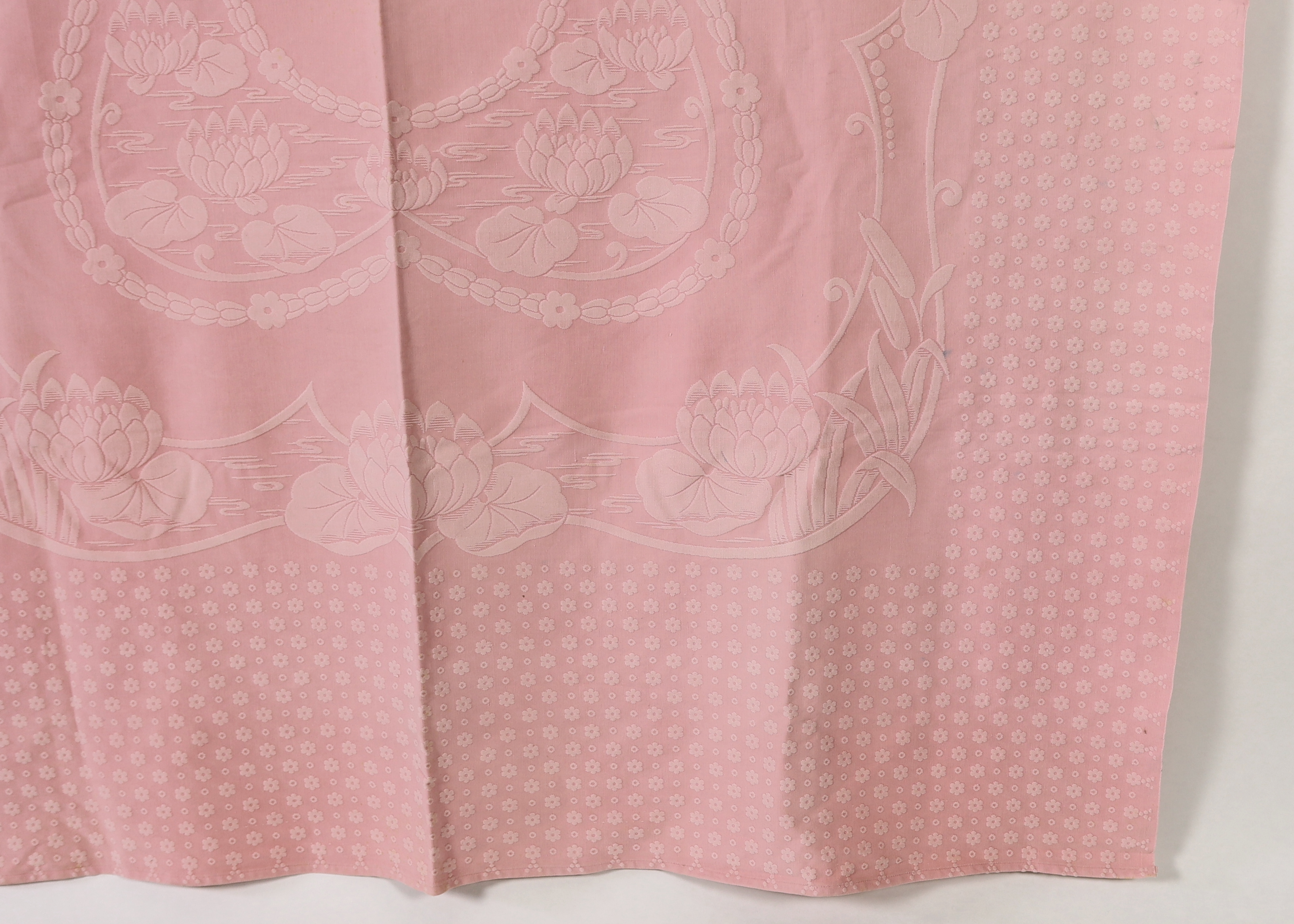 An early 20th century pink lily pad and bull rush designed woven ‘Marcella’ bedspread, 192cm wide, 228cm long